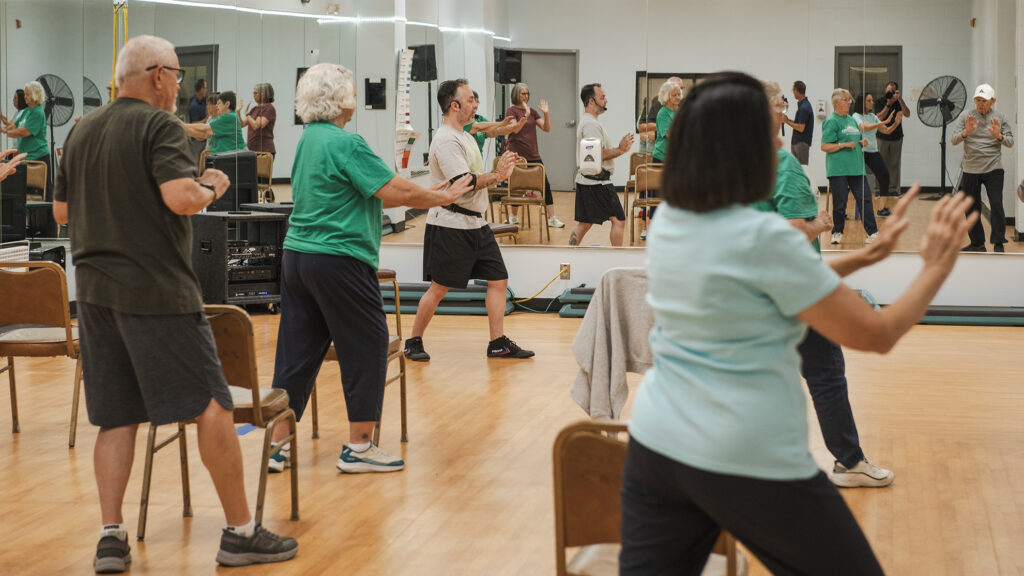 Fitness class with students following instructors movements